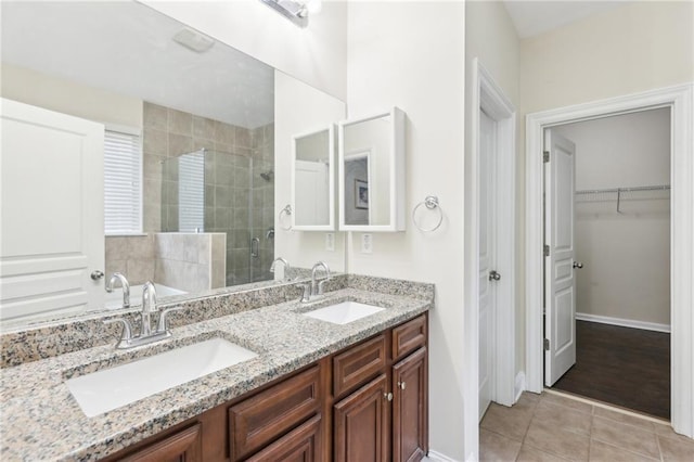 2760 Lions Gate Dr, Cumming, GA 30041 - full bath with a stall shower, tile patterned flooring, a walk in closet, double vanity, and baseboards