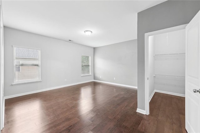 2760 Lions Gate Dr, Cumming, GA 30041 - unfurnished bedroom with a walk in closet, dark wood-style flooring, a closet, and baseboards