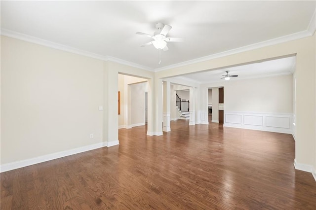 2760 Lions Gate Dr, Cumming, GA 30041 - unfurnished living room with ceiling fan, stairs, crown molding, dark wood-type flooring, and wainscoting