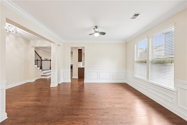 2760 Lions Gate Dr, Cumming, GA 30041 - empty room featuring a ceiling fan, stairs, wood finished floors, wainscoting, and crown molding