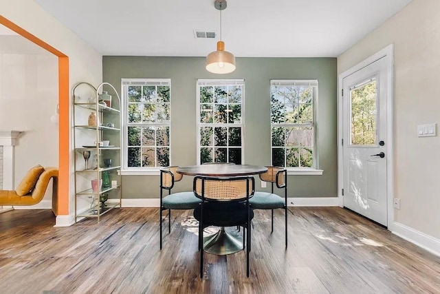 dining room featuring visible vents, baseboards, and wood finished floors