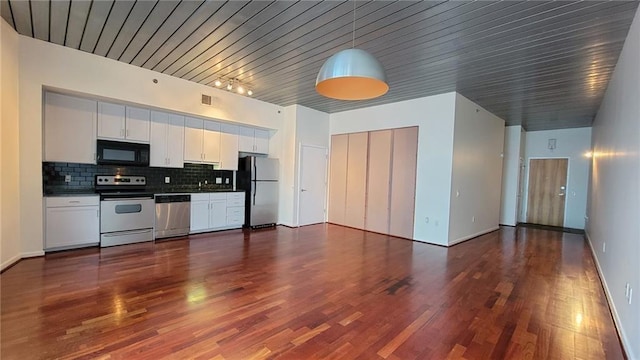 kitchen featuring hanging light fixtures, appliances with stainless steel finishes, dark hardwood / wood-style floors, white cabinets, and backsplash