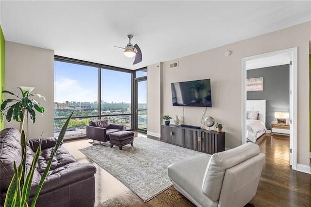 living room featuring dark hardwood / wood-style flooring, a wall of windows, and ceiling fan