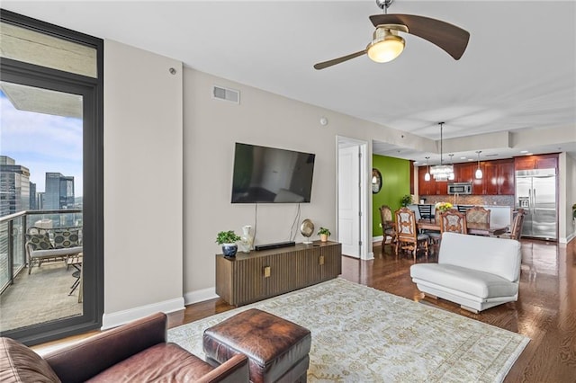 living room with dark hardwood / wood-style flooring and ceiling fan