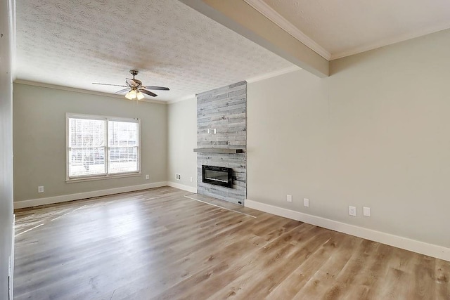 unfurnished living room featuring a tile fireplace, a textured ceiling, ceiling fan, and crown molding