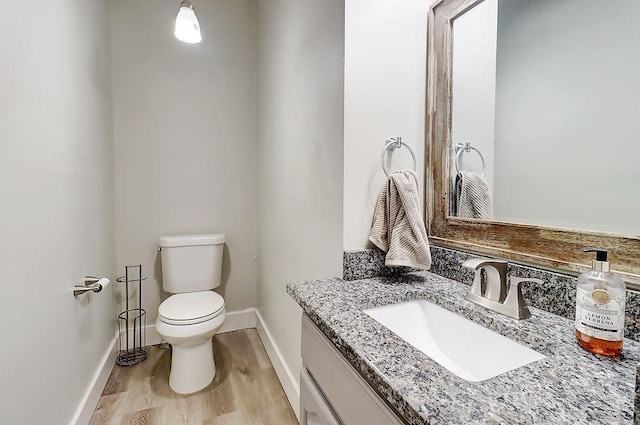 bathroom with toilet, wood-type flooring, and vanity