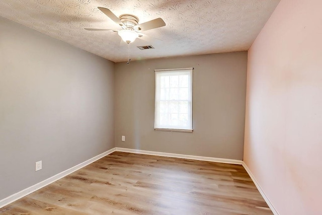 spare room with a textured ceiling, ceiling fan, and light hardwood / wood-style flooring