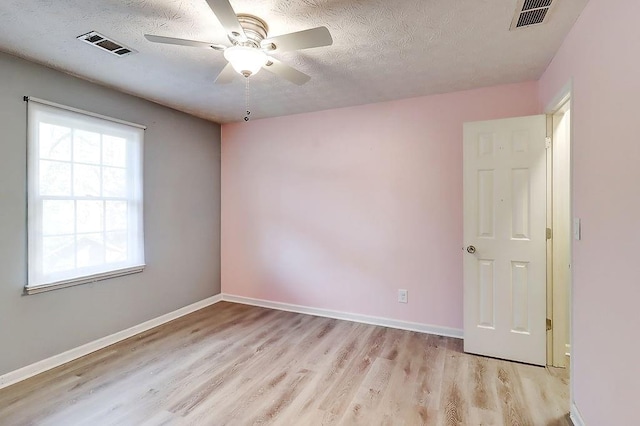 unfurnished room featuring a textured ceiling, ceiling fan, and light hardwood / wood-style flooring