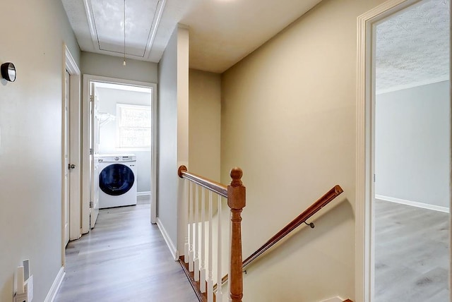 hallway with washer / dryer and hardwood / wood-style flooring