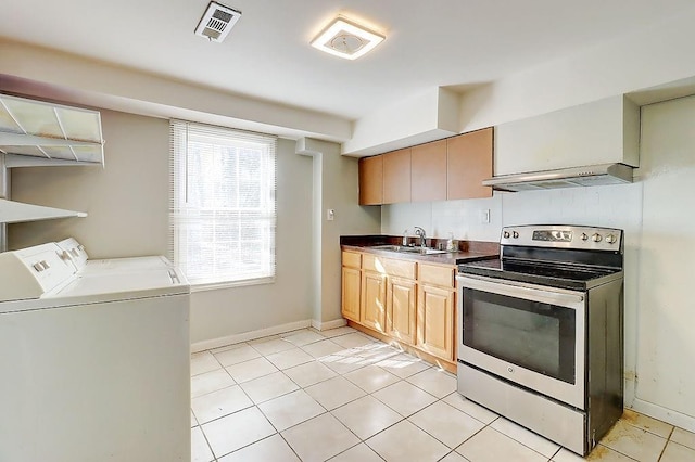 kitchen with sink, stainless steel range with electric cooktop, washing machine and dryer, and plenty of natural light