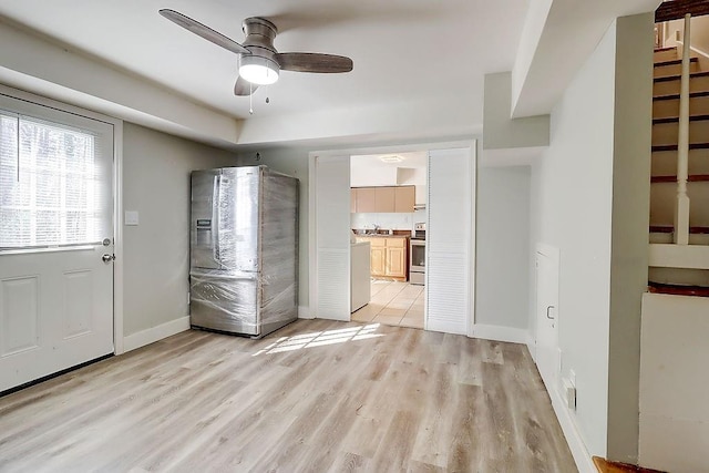 foyer entrance with sink, ceiling fan, and light wood-type flooring