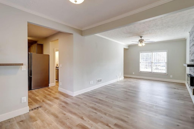 unfurnished living room featuring a stone fireplace, light hardwood / wood-style floors, crown molding, ceiling fan, and a textured ceiling