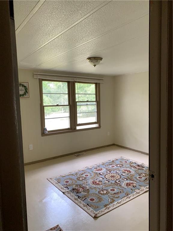 empty room with baseboards and visible vents