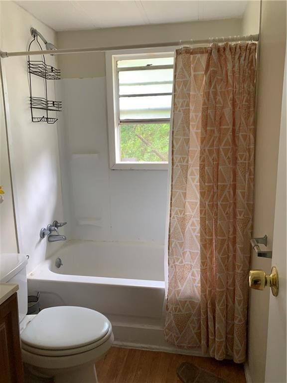bathroom with vanity, wood finished floors, shower / bath combination with curtain, and toilet