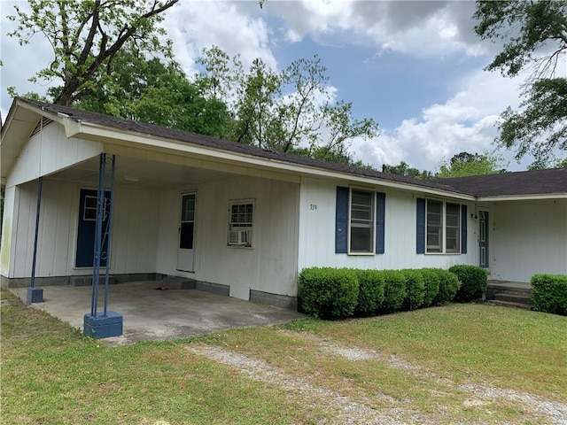 view of front of house with dirt driveway, a front yard, and a carport