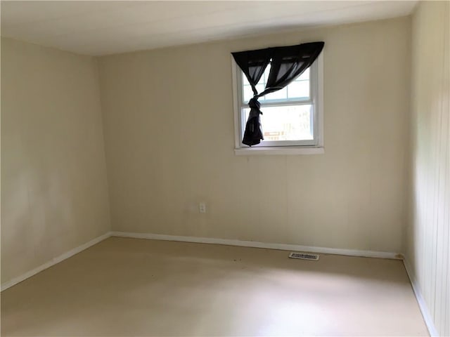 unfurnished room with baseboards, visible vents, and concrete floors