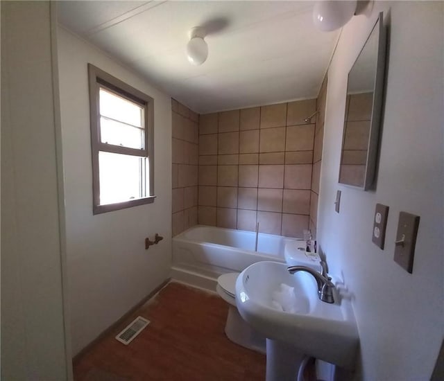 full bath with visible vents, wood finished floors, baseboards, toilet, and shower / bathtub combination