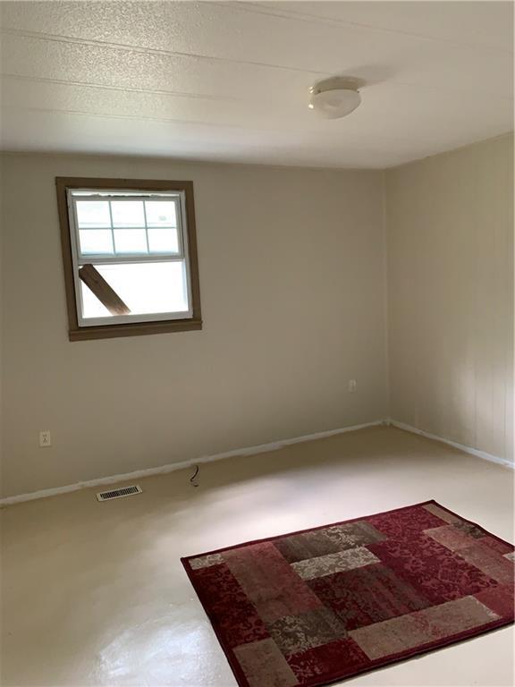 spare room with baseboards and visible vents