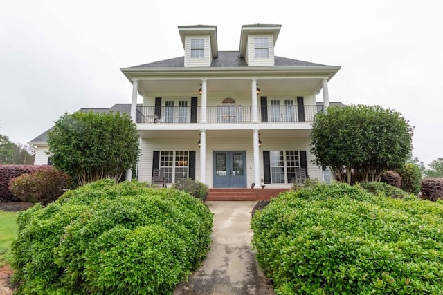 view of front of property featuring a balcony and french doors