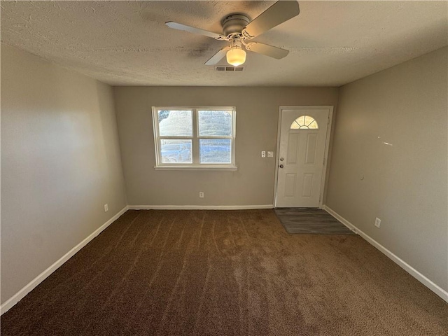 carpeted entryway featuring a textured ceiling and ceiling fan