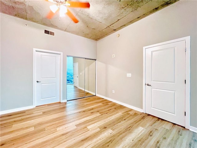 unfurnished bedroom featuring a closet, light hardwood / wood-style floors, and ceiling fan