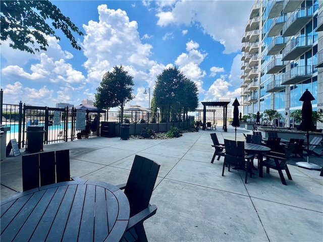 view of patio with a community pool and a balcony