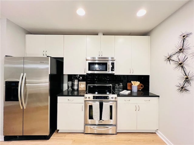 kitchen featuring white cabinetry, backsplash, appliances with stainless steel finishes, and light wood-type flooring