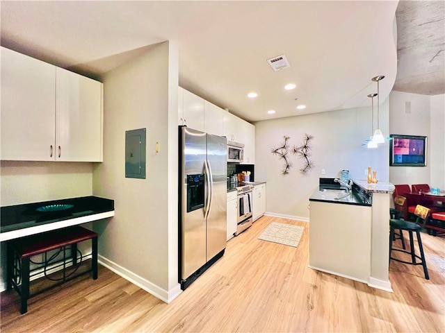 kitchen featuring white cabinets, appliances with stainless steel finishes, electric panel, and hanging light fixtures