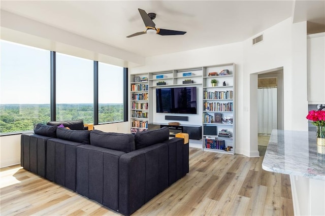 living room with light wood-type flooring and ceiling fan