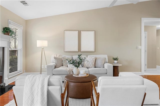 living area with visible vents, baseboards, and wood finished floors