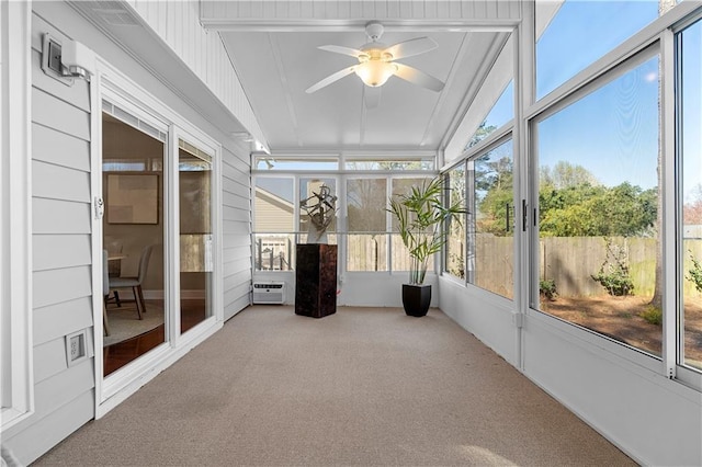 unfurnished sunroom featuring ceiling fan