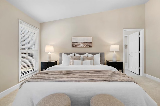 bedroom featuring multiple windows, light colored carpet, and baseboards