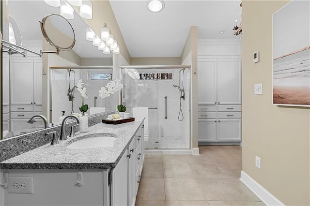 full bath with vanity, baseboards, an inviting chandelier, a stall shower, and tile patterned flooring