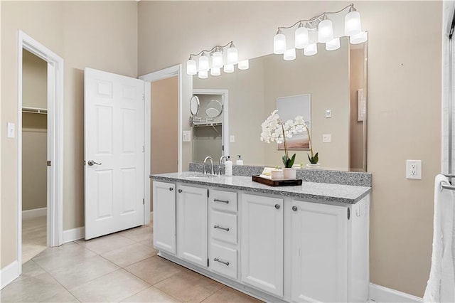 bathroom with tile patterned floors, baseboards, and vanity