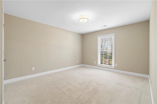 empty room with light carpet, visible vents, and baseboards