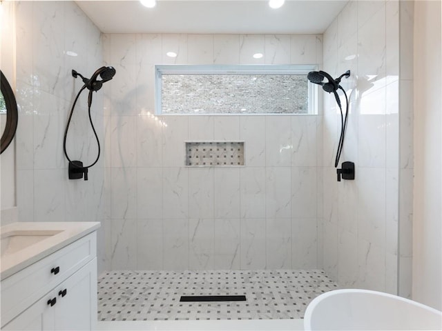 bathroom with tiled shower and vanity