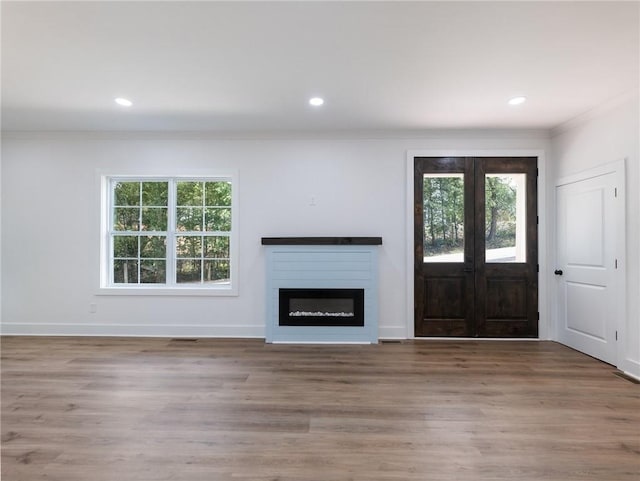 unfurnished living room featuring crown molding and hardwood / wood-style floors