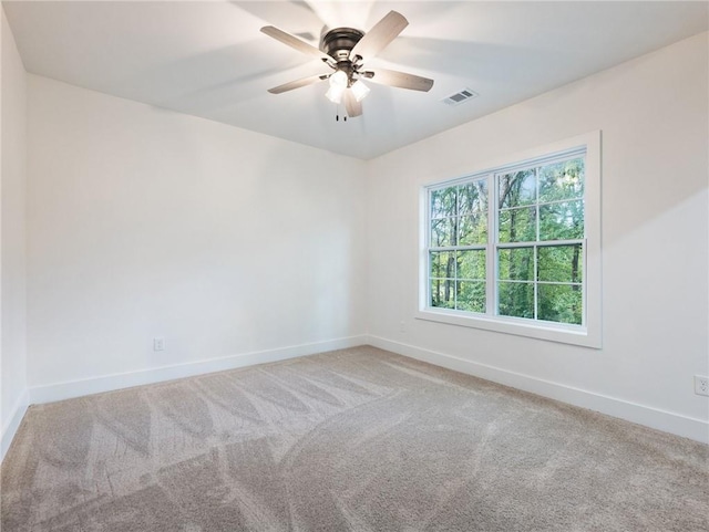 carpeted spare room with ceiling fan