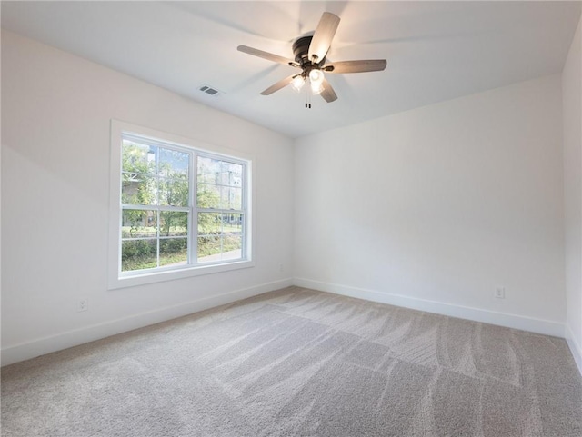 carpeted spare room featuring ceiling fan