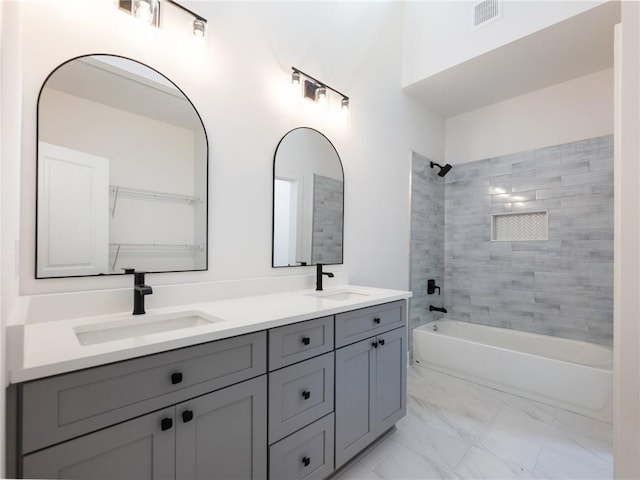 bathroom featuring tiled shower / bath combo and vanity