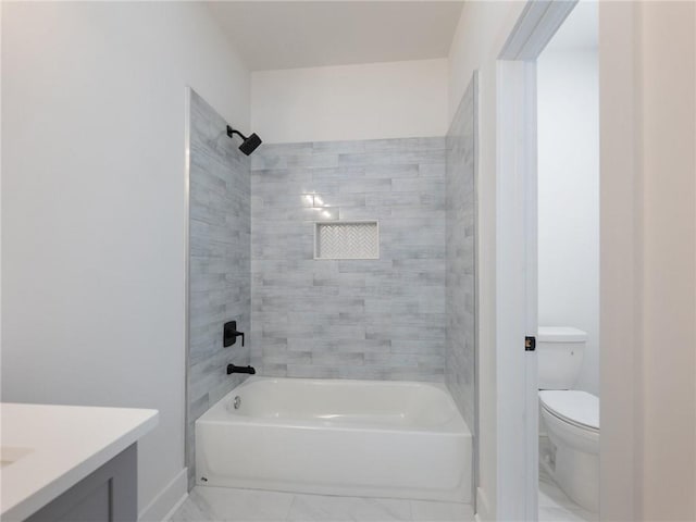 full bathroom featuring tiled shower / bath, vanity, and toilet