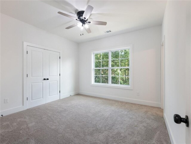 unfurnished bedroom with light carpet, a closet, and ceiling fan