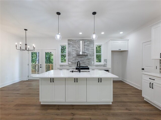 kitchen with dark wood-type flooring, wall chimney exhaust hood, plenty of natural light, and sink