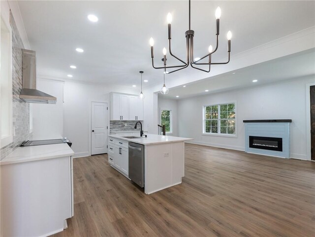 kitchen with dark wood-type flooring, white cabinets, dishwasher, pendant lighting, and wall chimney range hood