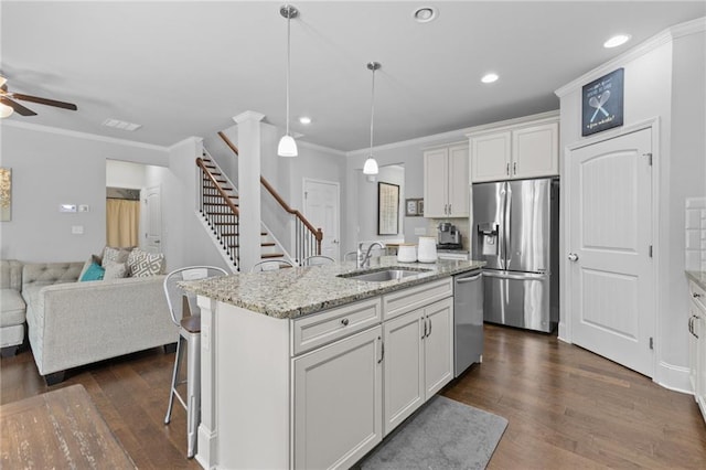 4568 Mantova Dr, Buford, GA 30519 - kitchen featuring stainless steel appliances, a sink, open floor plan, dark wood finished floors, and white cabinetry