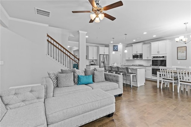 4568 Mantova Dr, Buford, GA 30519 - living room with ceiling fan, stairs, crown molding, recessed lighting, and a chandelier