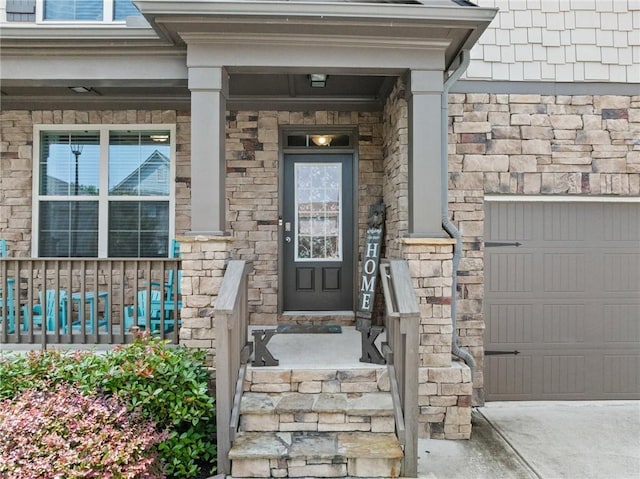 4568 Mantova Dr, Buford, GA 30519 - view of exterior entry with covered porch, a garage, stone siding, and driveway
