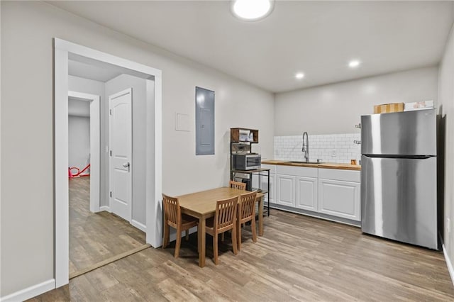4568 Mantova Dr, Buford, GA 30519 - kitchen featuring stainless steel appliances, a sink, wooden counters, white cabinetry, and electric panel