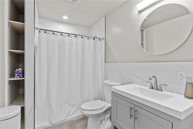 4568 Mantova Dr, Buford, GA 30519 - bathroom featuring toilet, vanity, tile walls, a shower with shower curtain, and recessed lighting