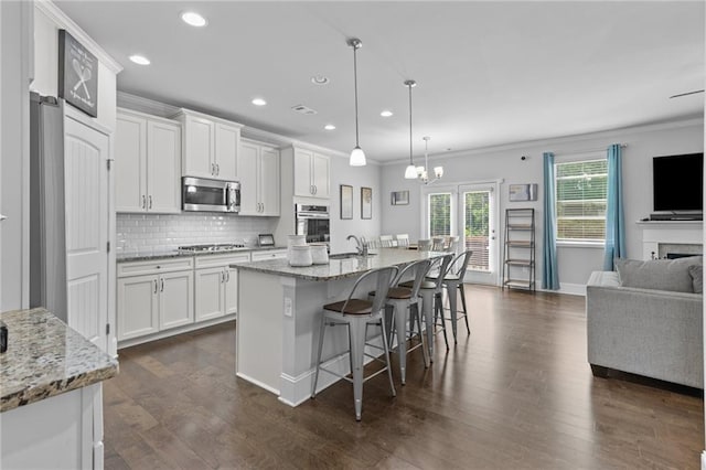 4568 Mantova Dr, Buford, GA 30519 - kitchen with appliances with stainless steel finishes, crown molding, open floor plan, recessed lighting, and white cabinets